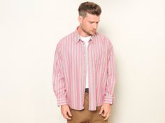 "This is a very charming and comfortable vintage 90's striped men's shirt in pink-blue. Durable and functional garment. Made of cotton. Vintage condition level 4 (very minor signs of wear) MODEL measurements: 6 ft (180 cm); he wears the size available. SIZE: Marked size: XL. To be sure the size will fit check the sizing details listed below. FLAT Measurements: Length from shoulder: 29 1/2 \" / 74,5 cm Armpit to armpit: 28 \" / 71,5 cm SKU: M8274 AMP * We assess the condition of our vintage items Oversized Long Sleeve Retro Shirt, Pink Retro Shirt With Relaxed Fit, Casual Oversized Striped Shirt, Retro Pink Long Sleeve Shirt, Retro Long Sleeve Shirt With Vertical Stripes, Vertical Stripes Shirt Men, Vintage Pink Buttoned Shirt, Pink Shirt Men, Vintage Suede Coat