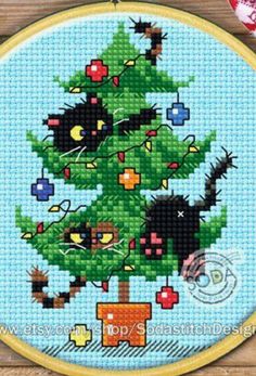 a cross stitch christmas tree with black cats