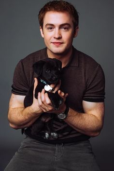 a man holding a puppy in his hands