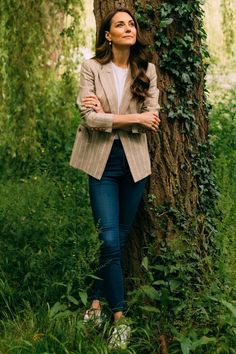 a woman leaning against a tree in the woods