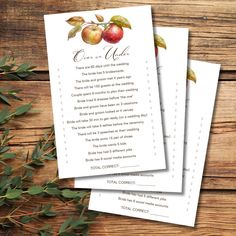 two wedding programs with apples on them and greenery in the background next to each other