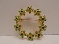 "Hello, here I have a vintage brooch pin, gold tone metal round with light green and dark green rhinestones.  The brooch is in very good condition, please see pictures as they are part of the description.  The measurements are, 1 3/8\" diameter. I accept best offers, just send me a message and I will get back with you promptly. I will ship your item within 24 hours, I take great care when packing your item for shipping so that it will make it to you safely. Thank you for stopping by and have a g Green Round Brooch For Formal Occasions, Green Round Brooch For Gift, Green Round Brooches For Gift, Green Round Brooches For Wedding, Green Round Wedding Brooches, Crystal Champagne Flutes, Crystal Champagne, Metal Leaves, Waterford Crystal