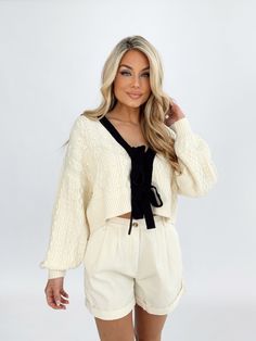 Elevate your wardrobe with our Chic Bow Charm Cardigan. This cable knit cardigan is both soft and stretchy, with a v neckline and front tie details that add a touch of chic to any outfit. The balloon sleeves, cropped length, and drop shoulders make it perfect for dinner, drinks, and even work wear in the spring and summer. Upgrade your style with this trendy and sophisticated piece. Shell 60% Acrylic 40% Nylon Hand wash cold. Chic Cable Knit V-neck Cardigan, Chic Cropped Cream Sweater, Cream V-neck Cable Knit Cardigan, Chic Cable Knit Sweater For Day Out, Dinner Drinks, Cable Knit Cardigan, Balloon Sleeves, The Balloon, Dresses Xs