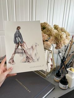 a person holding up a card with a drawing of a man walking a dog