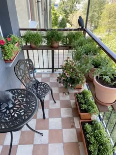 an outdoor balcony with potted plants and chairs