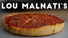 a deep dish pizza sitting on top of a metal pan with the words lou malnati's written above it