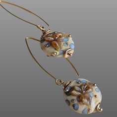 "Description: Add incredible sophistication to your look with our Flawless Romance glass long earrings. These unique beige earrings, with an expertly crafted floral motif in shades of blue, add incomparable beauty to your style. Peculiarities: Lampwork Craftsmanship: Each bead embedded in these earrings is handcrafted using the lampwork technique, making them unique and one of a kind. Floral Motif: The harmony of blue and beige colors in floral patterns will add tenderness and romance to your appearance. Sterling Silver Fittings: Gold plated sterling silver fittings give the earrings a luxurious look. Impeccable Romance is the choice of those who strive for subtle sophistication and incomparable beauty. Give your look a unique touch with these stunning earrings. Order your pair now. ✧ ∙YOU Elegant Beige Flower Earrings For Gift, Elegant Beige Flower Earrings Gift, Elegant Flower Earrings With Czech Glass, Elegant Czech Glass Flower Earrings, Elegant Beige Nickel-free Earrings, Artsy Earrings, Beige Earrings, Aesthetic Earrings, Bohemian Flower