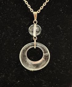 Lovely Coca Cola Live Positively recycled clear glass open round donut-shaped pendant with a clear glass ball above the pendant. The pendant is on an adjustable 17.5" to 20" silver-tone chain, with a silver-tone Coca Cola bottle tag. The necklace and pendant are in good condition, with very slight tarnish. The original Coca-Cola tag is attached. This is a lovely versatile necklace which would complement any outfit and is also eco-friendly. Please message with any questions. Modern Clear Round Jewelry, Clear Glass Pendant Jewelry, Adjustable Clear Pendant Jewelry, Clear Glass Round Pendant Jewelry, Adjustable Clear Jewelry, Adjustable Round Clear Jewelry, Adjustable Clear Necklace, Cola Bottle, Bottle Tags