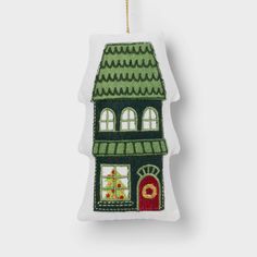 a green house ornament hanging on a white wall