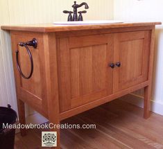 a wooden sink cabinet with two faucets on it