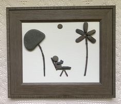 the shadow of a person sitting in a chair next to two dragonflies and a rock