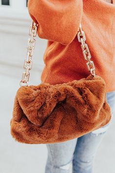 We think the current faux fur purse trend is so new and exciting that we just had to get some for ourselves! This adorable brown handbag featuring ultra plush material, a large gold chain link handle, and a fully lined interior! Purse Trends, Faux Fur Purse, Fur Purse, Fur Handbags, Patent Heels, Brown Handbag, Model Fits, Chain Shoulder Bag, Women Clothing Boutique