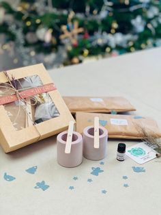 a couple of candles sitting on top of a table next to a box with a ribbon