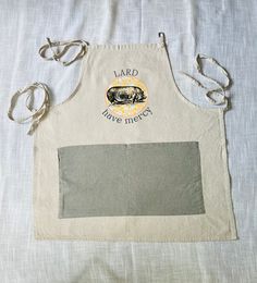 a white apron with an image of a pig on it and the words hard have mercy