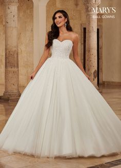 a woman in a white wedding dress posing for the camera