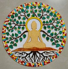 a decorative plate with a buddha sitting in front of a tree on top of it