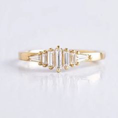 three stone diamond ring in yellow gold with baguets on the sides and side stones