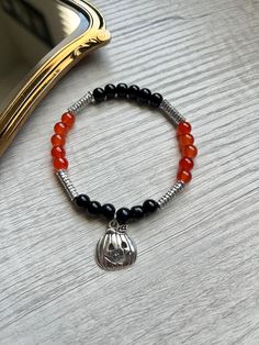 🎃 Halloween Bracelet 🎃  Orange and black 6mm glass beads with silver accents.  SIZE: S/M  🖤JEWELRY CARE: Avoid direct contact with lotions, perfumes and soap or other chemicals that could cause discoloration.  🧡TIPS: Remove before showering, swimming, or other water activities. ⚠️ WARNING: Bracelets are made with small beads that could be a choking hazard.  - Do not leave children unattended with jewelry. - Excessive stretching can lead to breaking/ tearing the bracelets Halloween Black Bracelets With Round Beads, Black Round Bead Bracelets For Halloween, Black Beaded Bracelets For Halloween, Black Round Beaded Bracelets For Halloween, Black Beaded Bracelet For Halloween, Black Beaded Stretch Bracelet For Halloween, Black Stretch Bracelet With Round Beads For Halloween, Black Nickel-free Bracelets With Round Beads, Pumpkin Bracelet