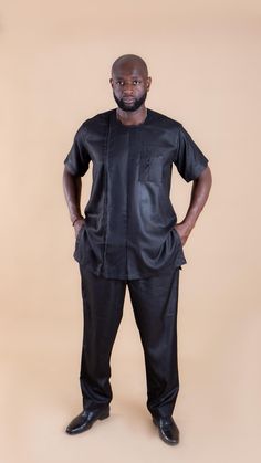 Our Elegant African Men Short Sleeve Suit This two-piece suit is the epitome of regal elegance, fit for a king. The delicate golden embroidery around the neckline adds a touch of opulence, with intricate details meticulously crafted for versatility, making it suitable for various occasions and functions. This exceptional suit is not just a garment; it's a statement.  FEATURES Men's Short Sleeve Suit Colour (s): Black Shirt: Rounded Collar Embroidery Pocket design Trousers: Jogger Style Zipper to Semi-formal Fitted Short Sleeve Suits, Elegant Fitted Pant Set With Set-in Sleeves, Classic Fitted Short Sleeve Sets, Traditional Gold Semi-formal Sets, Classic Fitted Ceremonial Suit, Traditional Fitted Sets With Set-in Sleeves, African Men Wear, Design Trousers, Shirt And Trouser