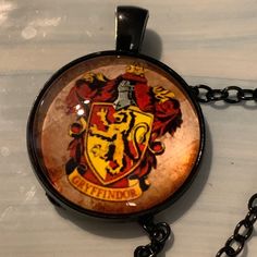 a necklace with a hogwarts crest on it sitting on a white counter top