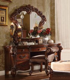 a wooden desk with a mirror on top of it next to a couch and chair