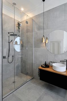 a bathroom with a sink, mirror and shower stall in it's corner area