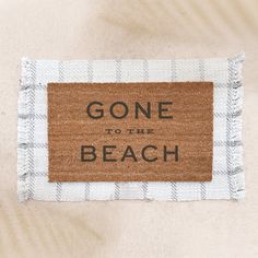 a door mat that says gone to the beach