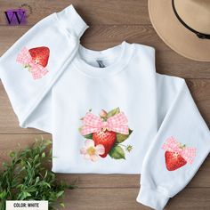 Our sweatshirt boasts a whimsical and vibrant strawberry print for any and all strawberry lovers. Each strawberry is a burst of juicy red and vibrant green, creating a fresh and cheerful look that's perfect for any season. The sleeve print is adorable and adds a feminine look to the sweatshirt. Perfect Gift Pairing: Whether you're treating yourself or surprising a loved one, this combo makes for an unforgettable gift. Wear to the Strawberry Festival, School, Farmers Market, Vacation or around to Sweet White Tops With Strawberry Print, Sweet Strawberry Print Crew Neck Top, Long Sleeve Cotton Tops With Strawberry Print, Trendy Sweatshirts, Strawberry Festival, Art Things, Strawberry Print, Vibrant Green, Print Sweatshirt