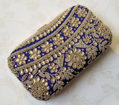 This EIRA Clutch is a stylish and unique accessory. Crafted with intricate embroidery in an eye-catching design, it's a sophisticated and versatile piece for your wardrobe. Perfect for adding a touch of flair to any outfit! Approximate Size: 20cm (L) x 4cm (W) x 12cm (H) Elegant Festival Embroidered Fabric, Elegant Embroidered Fabric With Dori Work For Celebration, Traditional Floral Embroidered Fabric For Evening, Traditional Evening Embroidered Fabric With Floral Design, Traditional Floral Embroidered Evening Fabric, Traditional Evening Embroidered Floral Fabric, Elegant Embroidered Fabric With Dori Work, Elegant Embellished Embroidered Fabric, Elegant Multicolor Embroidered Fabric