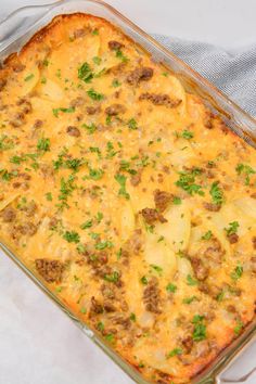 a casserole dish with meat and cheese in it on a white table cloth