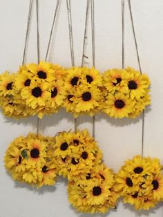 sunflowers are hanging on the wall with strings attached to each one's sides