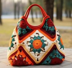 a crocheted handbag sitting on top of a stone floor next to trees