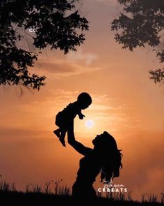 the silhouette of a woman holding a child in her arms as the sun goes down