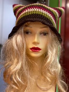 a mannequin wearing a knitted hat with red lips and long blonde hair