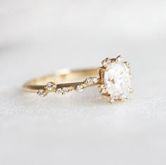 a close up view of a diamond ring on a white surface