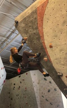 a woman climbing up the side of a rock wall