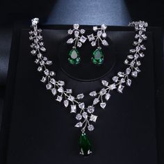 Make a stunning statement with this exquisite jewelry set, featuring a captivating emerald green cubic zircon necklace and earrings. Whether you're attending a wedding, a special event, or simply want to add a touch of sophistication to your ensemble, this set is the perfect choice. Key Features: Designed for the trend-conscious individual Elegant geometric shape and pattern Suitable for weddings and other special occasions Made of high-quality copper and adorned with shimmering cubic zirconia I Green Jewel Bridal Necklace For Anniversary, Green Emerald Jewelry Sets For Wedding, Green Jeweled Bridal Necklace For Anniversary, Green Emerald Wedding Jewelry Sets, Anniversary Green Jeweled Bridal Necklace, Green Sparkling Stones Jewelry Sets For Party, Green Cubic Zirconia Jewelry Sets With Matching Earrings, Cubic Zirconia Emerald Necklace For Wedding, Wedding Crystal Jewelry For May Birthstone