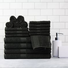 a stack of black towels sitting on top of a white counter