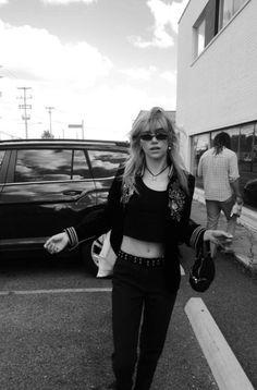 black and white photograph of a woman walking down the street