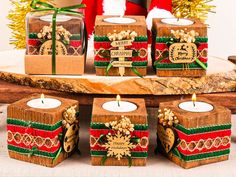 some candles are sitting on a table with presents in front of them and a santa clause