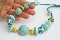 This beautiful necklace is made of polymer clay. All beads are different but in the same color range. The color is very delicate and at the same time bright turquoise with blue, and light yellow beads add contrast.  Some beads are made of transparent fimo, so the necklace is delicate and shimmering.  Small fish are also made of polymer clay.  They are turquoise with yellow tails. Very current details.  I think this necklace can be attributed to a work of art.  I like the result of my hard work. Fish Mermaid, Colorful Necklace, Small Fish, Turquoise Leather, Polymer Clay Necklace, Mermaid Necklace, Clay Necklace, Colourful Necklace, Art Handmade