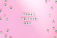 the word today is your day spelled with scrabbles on pink paper surrounded by letters