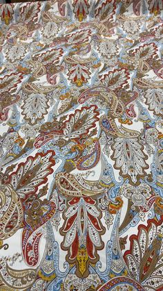 an intricately designed bedspread with many colors and patterns on the bed sheet