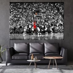 a black and white photo of a basketball game being played in front of an audience