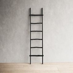 an empty room with a ladder leaning up against the wall and wood flooring in front of it