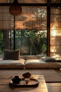 a living room filled with lots of furniture next to a large glass window covered in bamboo blinds