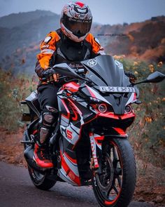 a man riding on the back of a motorcycle down a road