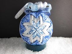 a blue and white ornament with snowflakes on it's side