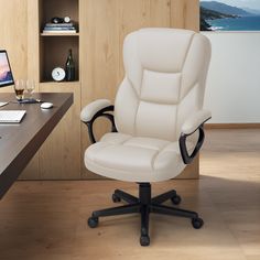 a white leather office chair sitting in front of a desk with a computer on it