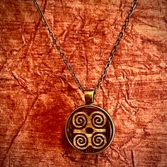 This unique  stained Native American necklace features an engraved wood round pendant inspired by nature . The 1 inch pendant hangs from a 20 inch bronze chain with clasp. The necklace is perfect for adding a touch of bohemian style to any outfit, and is made with quality materials sourced from the United States. Whether you're dressing up for a special occasion or just adding some flair to your everyday look, this pendant necklace is sure to be a standout piece in your collection....sustainable and eco friendly.. Note; wood grain and tint may differ. Symbolic Bronze Jewelry, Symbolic Engraved Copper Jewelry, Antique Gold Symbolic Engraved Jewelry, Symbolic Bronze Pendant Jewelry, Symbolic Bronze Brass Jewelry, Symbolic Engraved Antique Gold Jewelry, Etched Round Pendant Medallion Necklace As A Gift, Etched Medallion Necklace With Round Pendant As Gift, Etched Medallion Necklace With Round Pendant For Gift